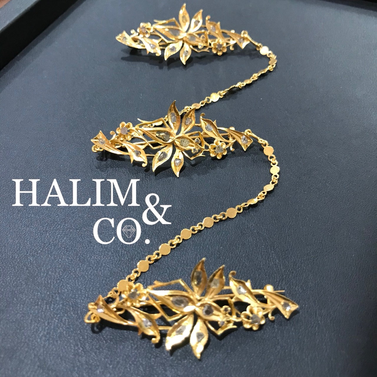 A gorgeous set of three antique gold brooches set with polki diamonds with patterned chains.