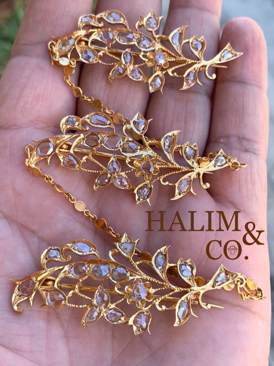 A gorgeous set of three antique gold brooches set with rose cut diamonds with patterned chains.